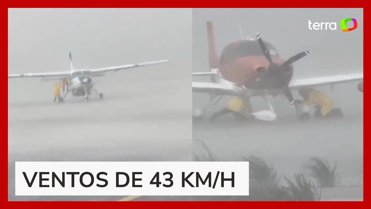 Homens se seguram em aviões durante temporal que derrubou hangar no