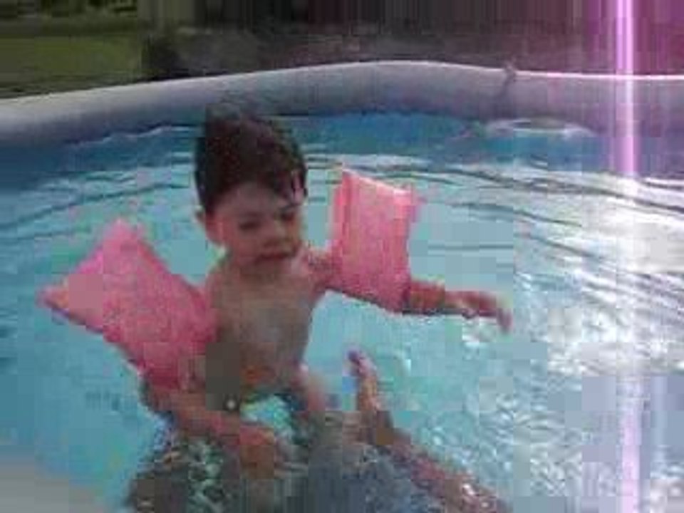 Lilou avec ses brassards dans la piscine