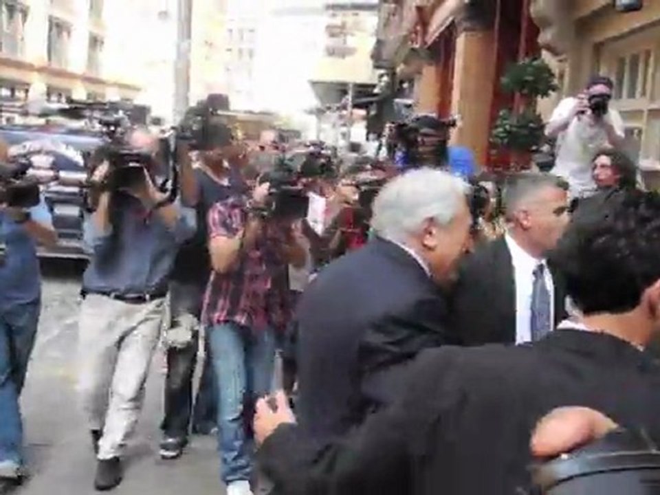 DSK hilare devant la meute de journalistes devant chez lui