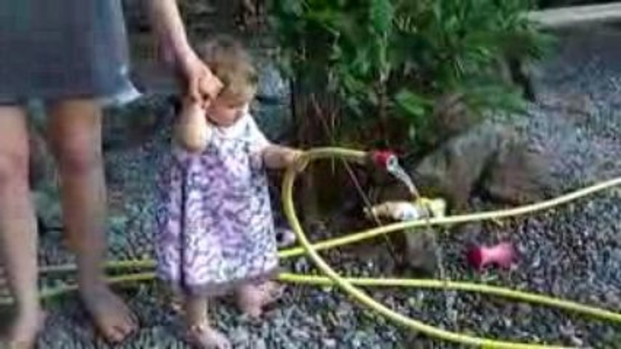 Maëlys en train d'arroser le jardin de Papy