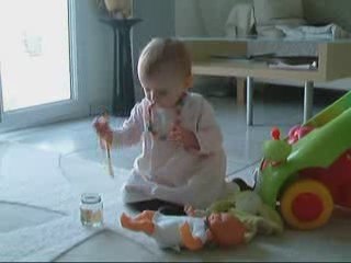 Petite Louise donne à manger à sa poupée