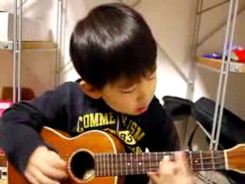 Un enfant joue une chanson de Jason Mraz au ukulele