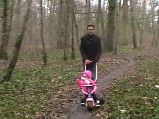 Rachel fait du tricycle dans les bois.