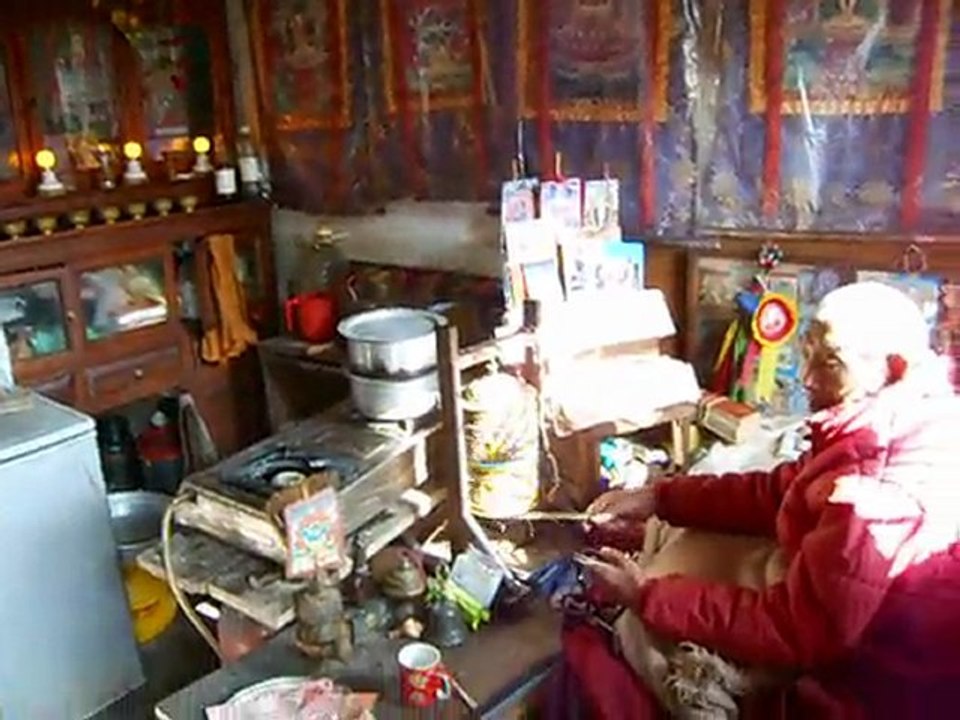 Moine bouddhiste utilisant son moulin à prières