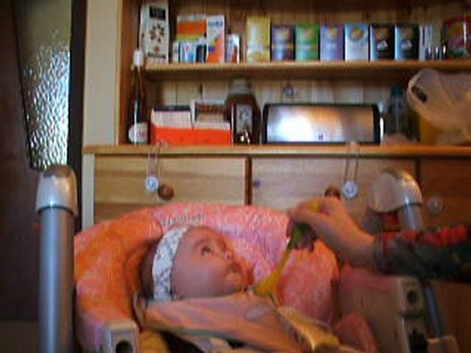 Ambre dans sa chaise haute qui mange sa compote