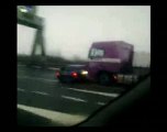 Truck pushes car along motorway