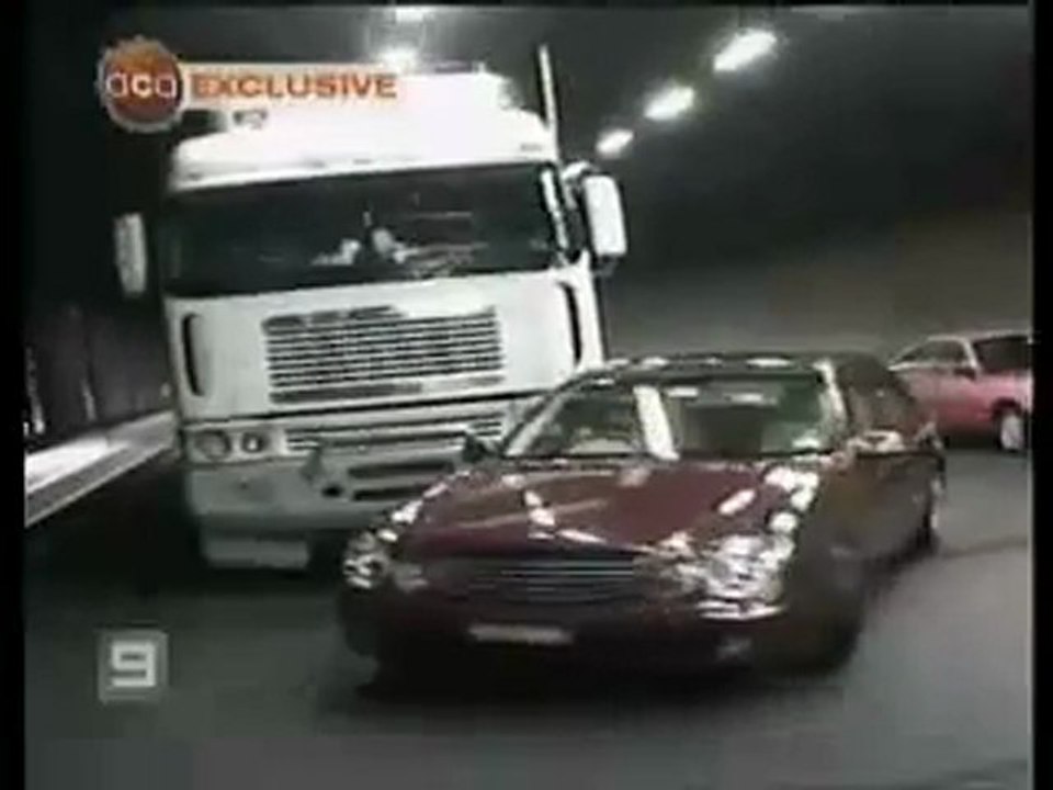 Un camion pousse une voiture dans un tunnel