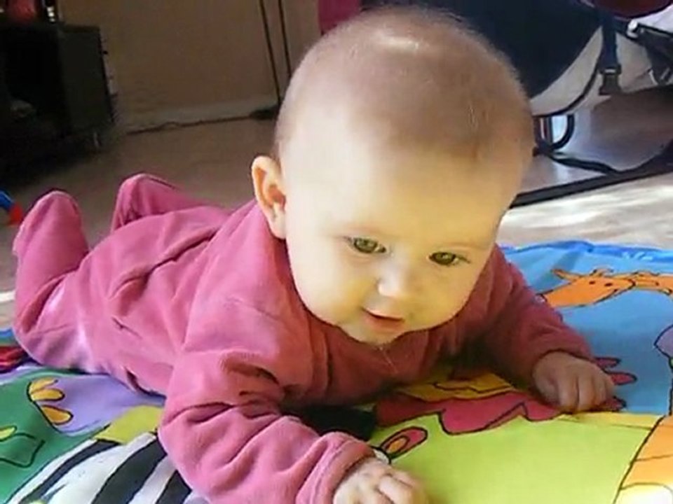 à plat ventre sur le tapis de jeux