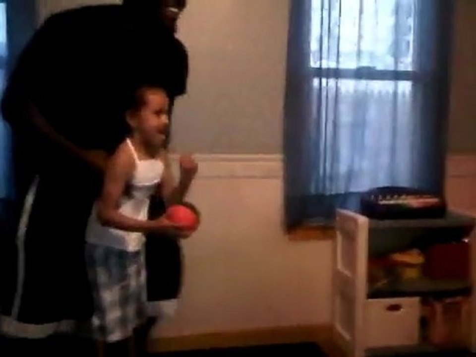 Une petite fille dunk dans son salon