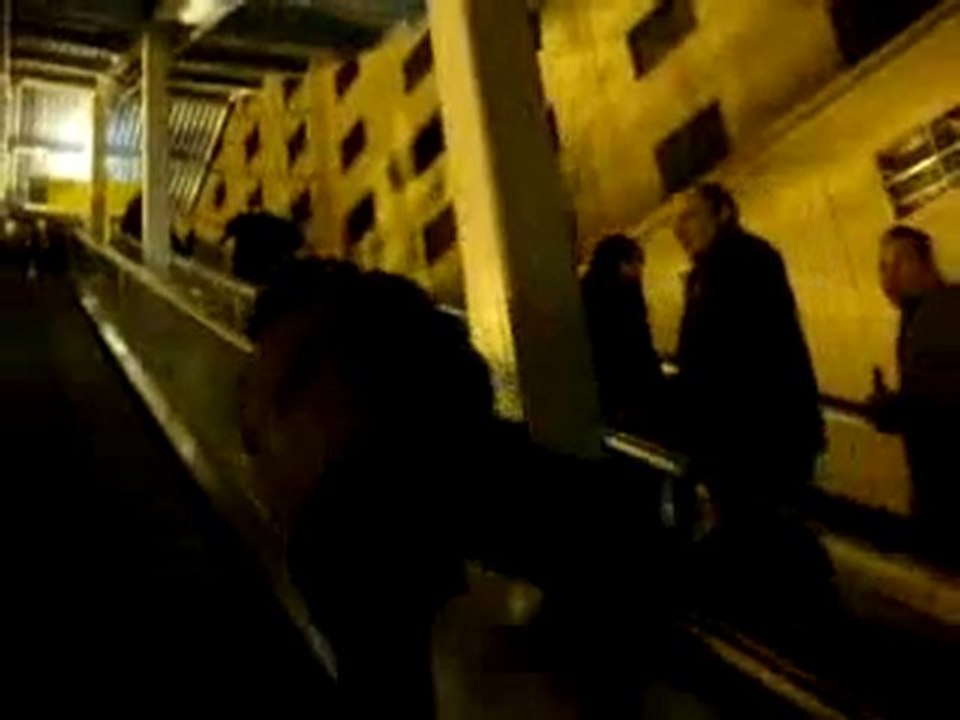 Régis glisse sur une rampe d'escalator