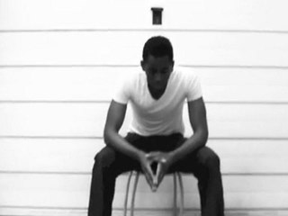 Un homme assis, en noir et blanc