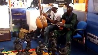 Mamadou Dramé joue de la kora au salon du  tourisme de Dakar