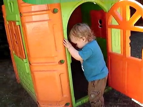 Adrien joue dans la cabane du jardin