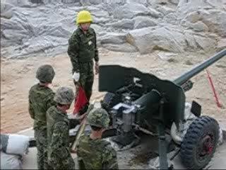 a soldier stands to close to artillery