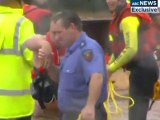 Firemen struggle to pull flash flood victims to safety