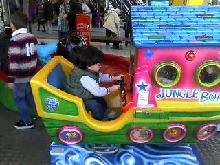 Rayan dans un petit manège d'enfants