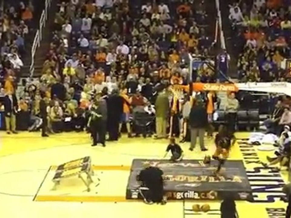 Un basketteur passe à travers le panier