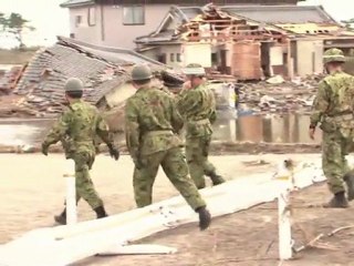 Japanese rescuers search through rubble at airport
