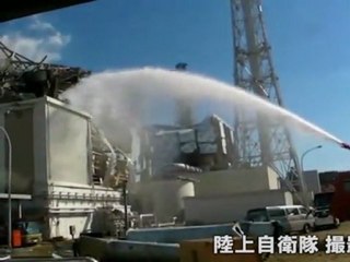 Emergency services brave radiation to spray water on reactor