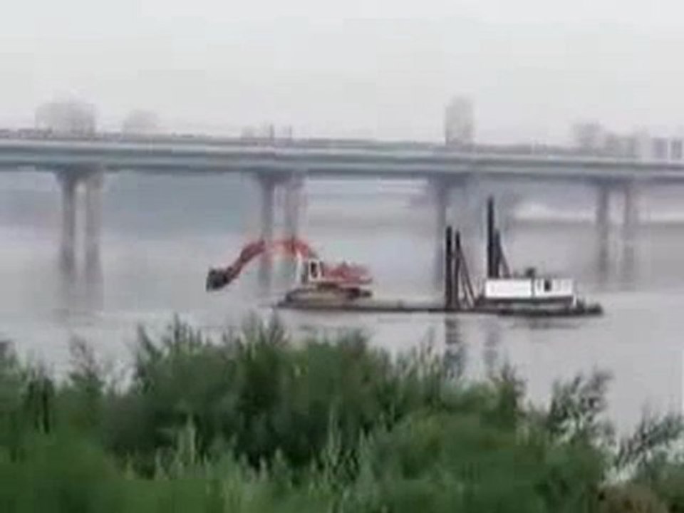 0226 - Mec joue avec un tractopelle sur un bateau