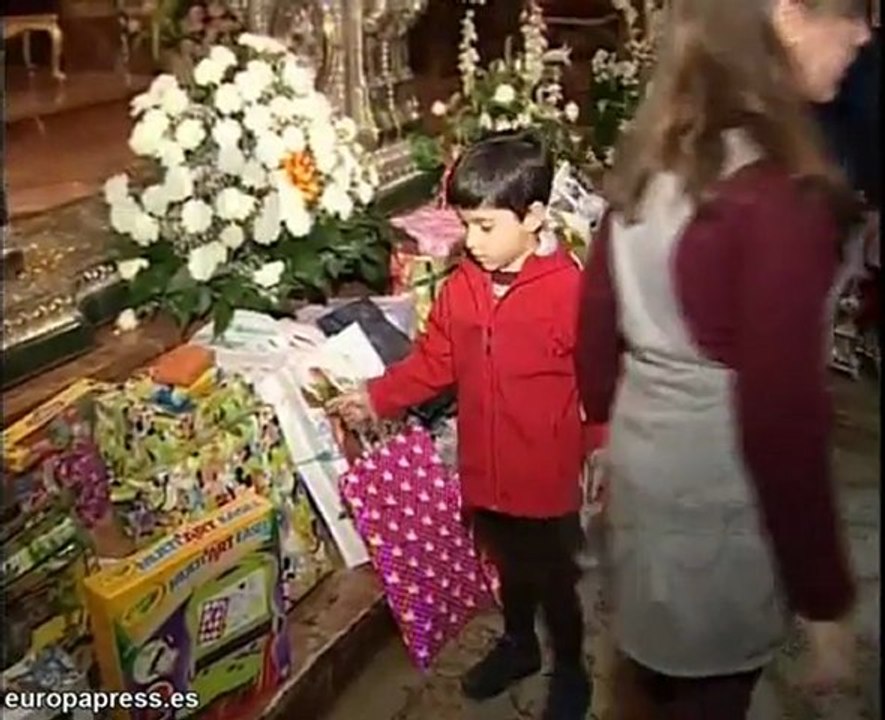 Niños sevillanos realizan una ofrenda de juguetes
