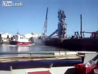 Crane falls while dropping a boat in water