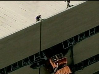 Truck dangles off tall building after crash