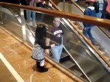 Chloe dit « Bye bye » aux gens dans l’escalator