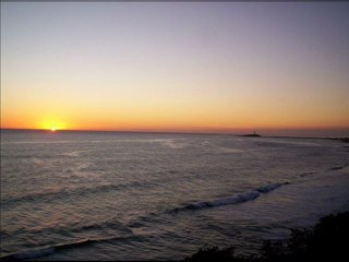 Puesta de Sol en Los Caños de Meca con la Atenta Mirada del Faro de Trafalgar