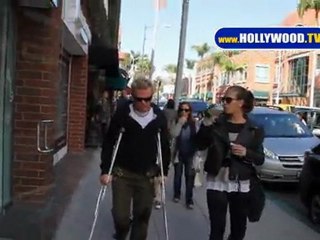 Billy Idol cojeando sobre muletas en Beverly Hills