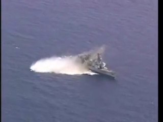 A torpedo hits a decomissioned US Navy ship during RIMPAC