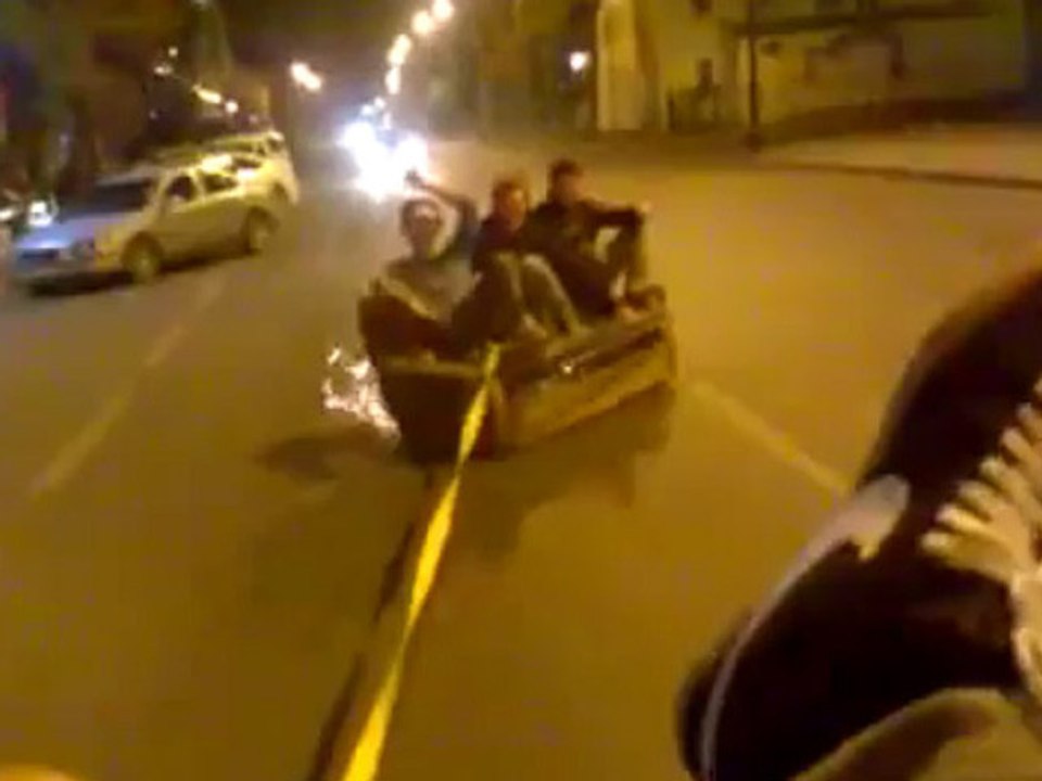 3 mecs dans un canapé, tiré par une voiture