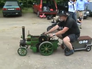 Ein Lokomobil wird entschlackt. Andere ziehen das Publikum