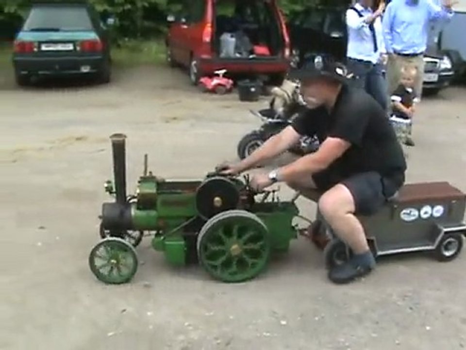 Ein lokomobil wird entschlackt. andere ziehen das publikum