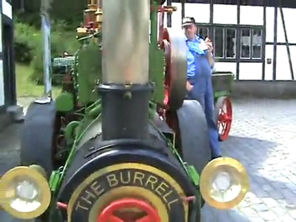 Holzgefeuertes Lokomobil tuckert im Leerlauf. Crew pausiert