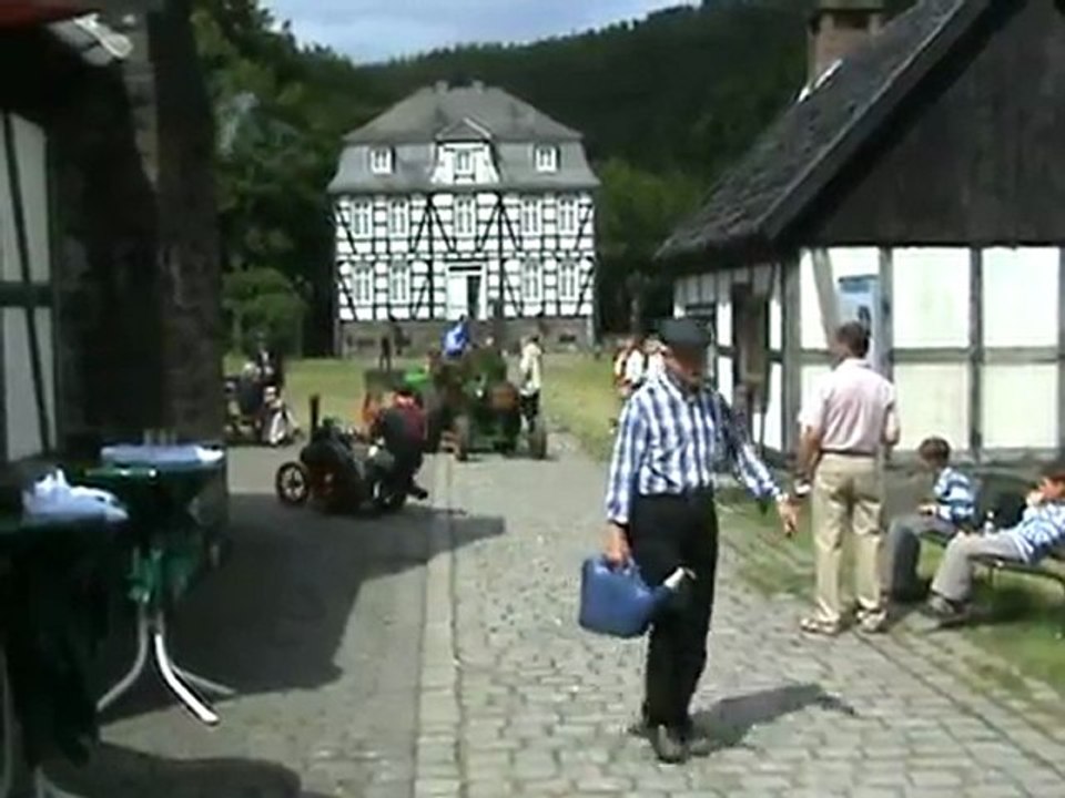 Ein Dampflokomobil fährt über die Brücke zur Wasserstelle
