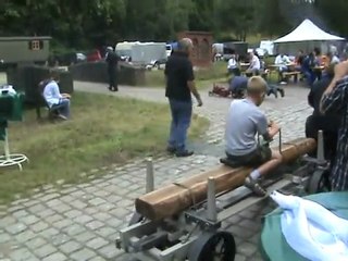 Lokomobilfahrer mit Kind auf dem Schoß fährt zur Brücke