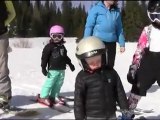 Niño se queda dormido de pie estando listo para aprender a esquiar.