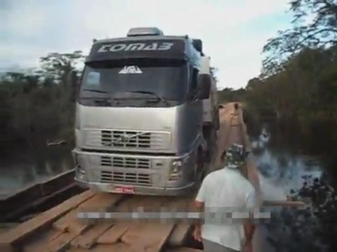 Un camion trop lourd bascule sur un pont en bois