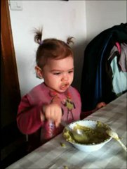 Jeanne (joue) mange avec sa cuillère