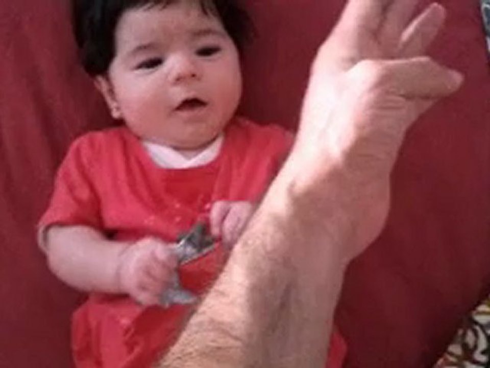 riendose en la cama con fondo rojo del 18 de mayo