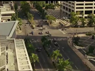 Mia guides Dom and Brian hauling the vault through the stree