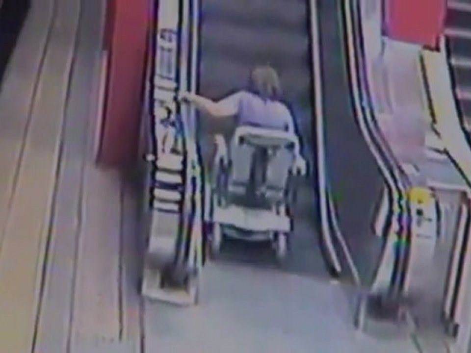 Handicapée en fauteuil roulant chute dans l'escalator