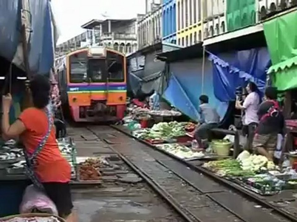 Shoppers bargain over train tracks at Thai market