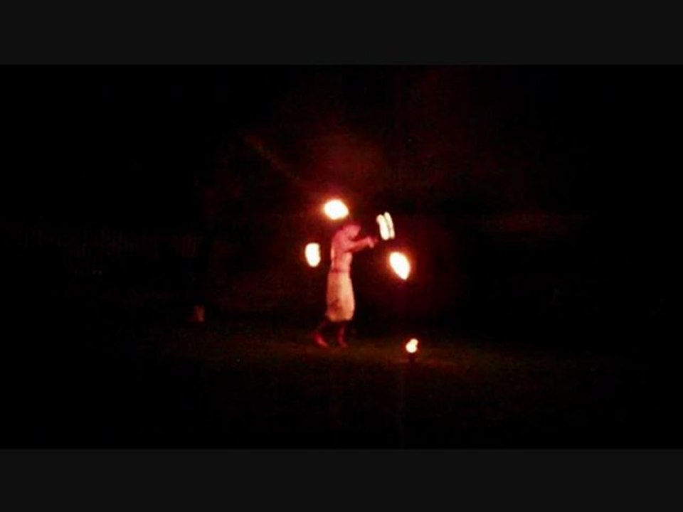 il jongle avec 2 staff et crache du feu en meme temps