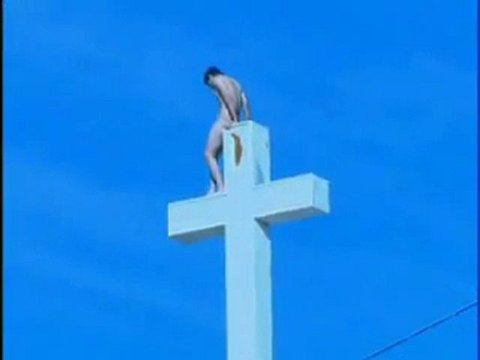 Homme nu fait caca sur le toit d'une église