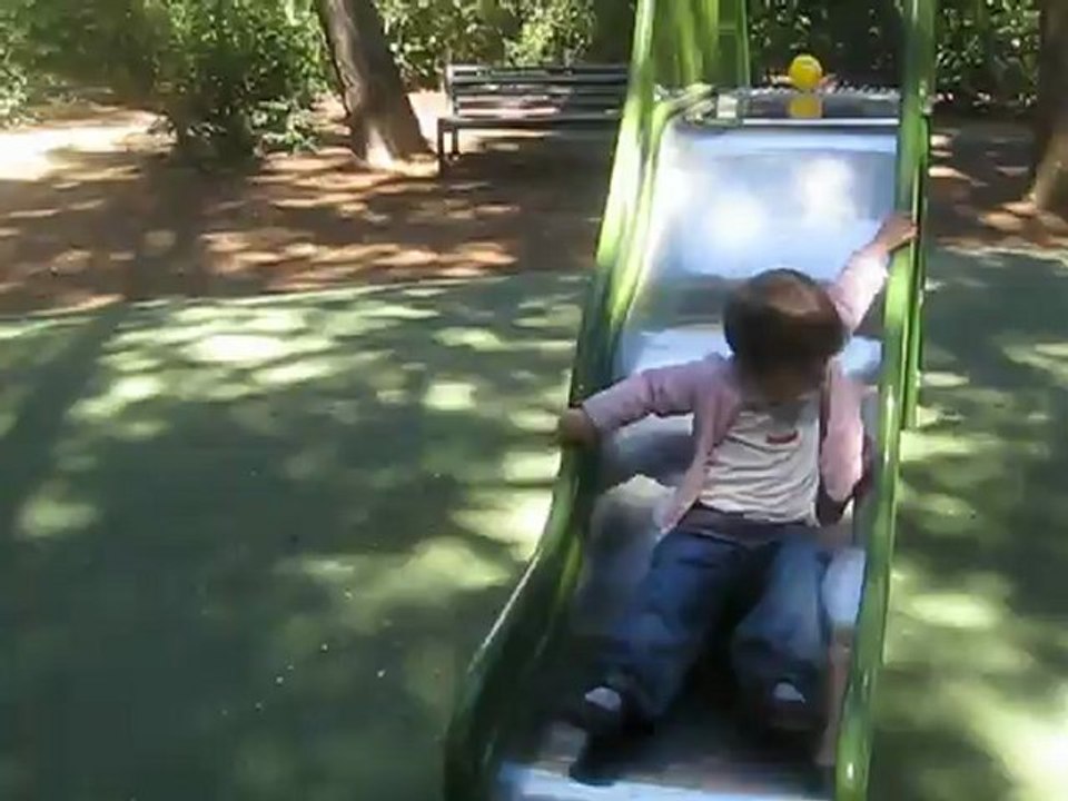 Charlotte au parc fait du toboggan