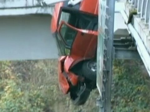 Truck hangs precariously off motorway bridge