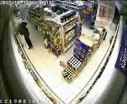 Man Shoplifting putting beer in own bag
