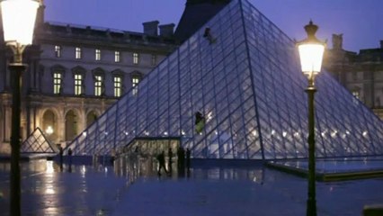 Activists scale the side of the Louvre Museum in Paris